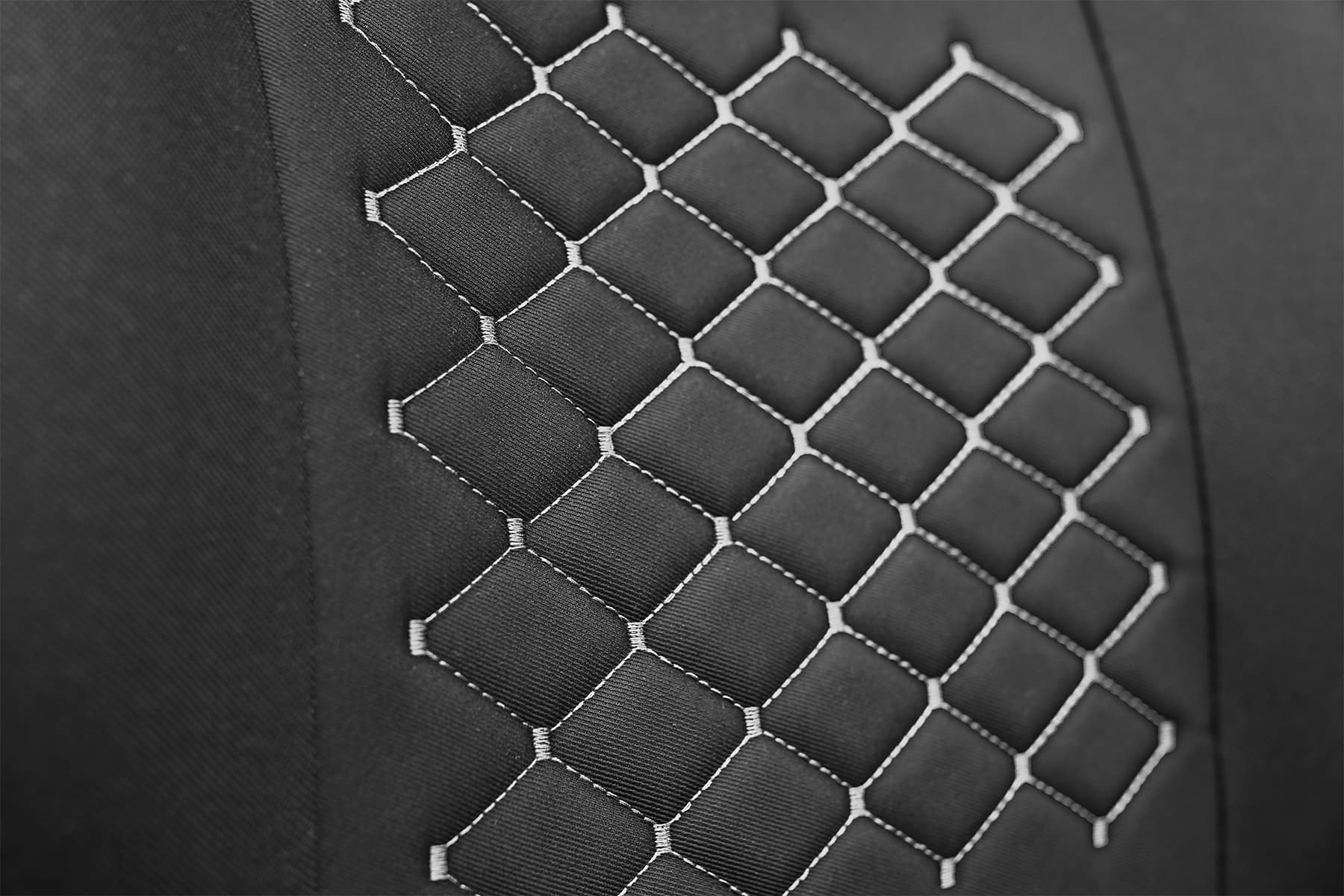 Detail van de bekledingsstof en grijze stiksels van de Motive T-shirt autostoelhoezen