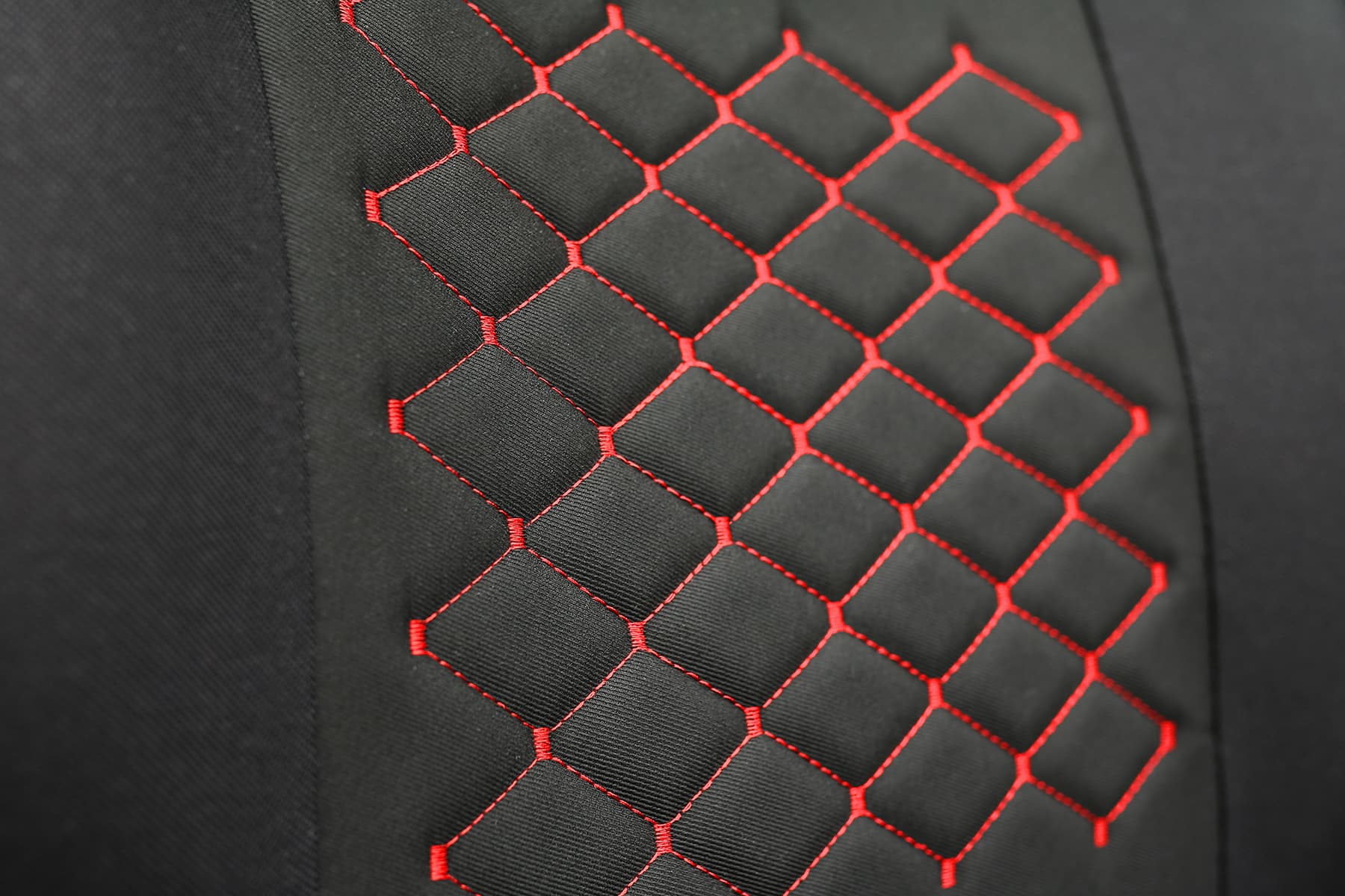 Detail van de bekledingsstof en rode stiksels van de Motive T-shirt autostoelhoezen
