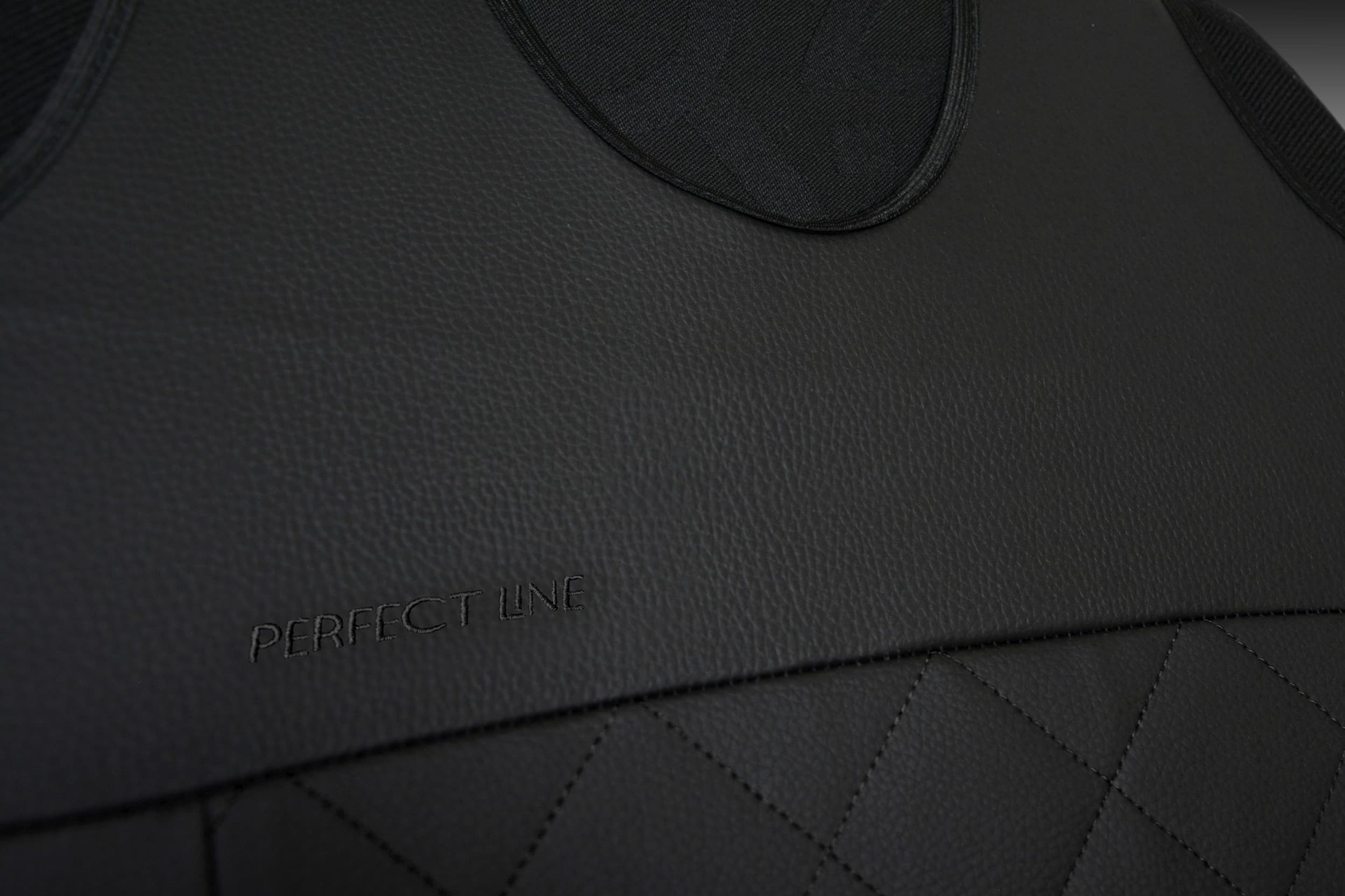 Detail van borduurwerk en stiksels op zwart eco-leer