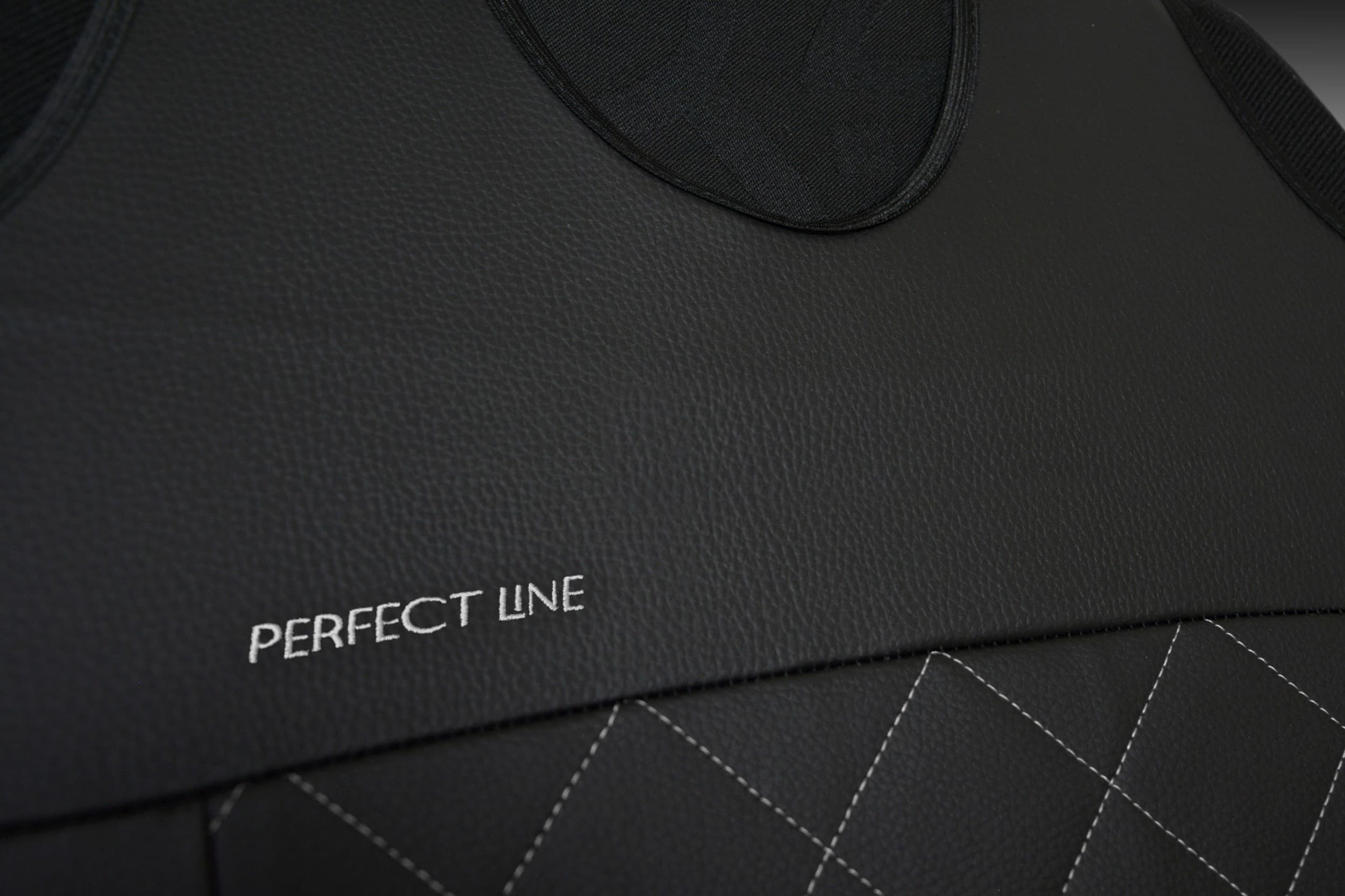 Detail van borduurwerk en stiksels op zwart eco-leer